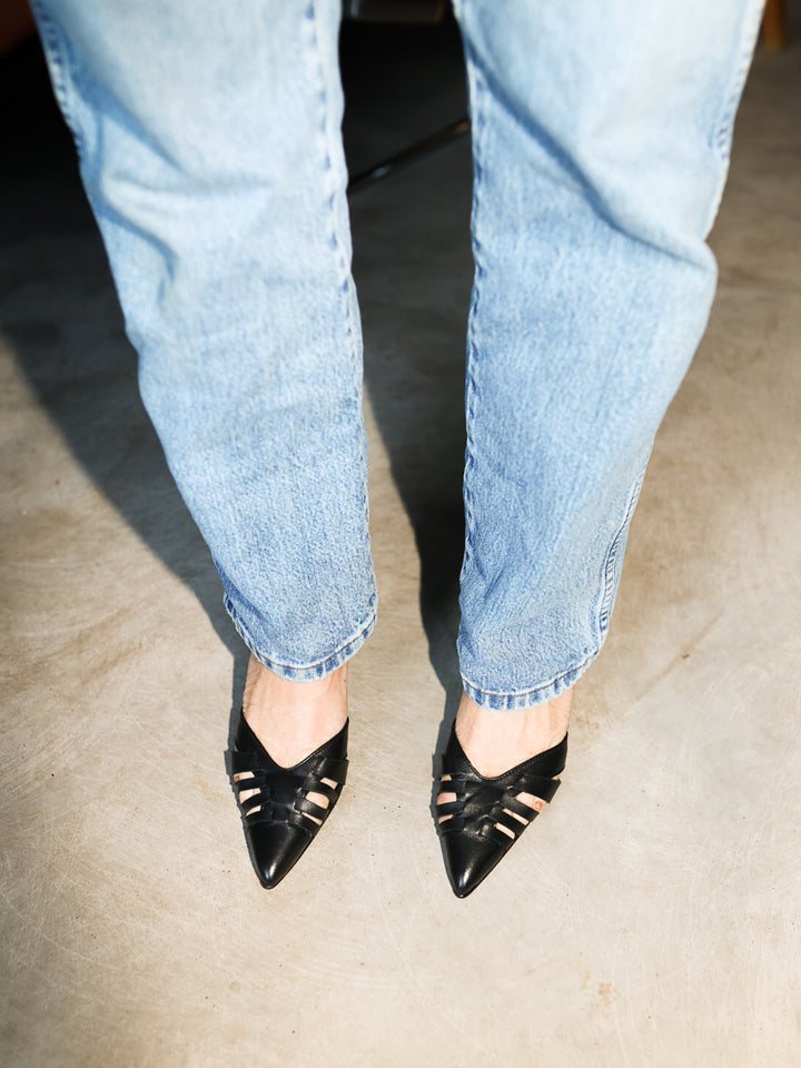 Blankens model wearing The Amanda with blue denim, black heels, pointed toe, braided leather, cut outs