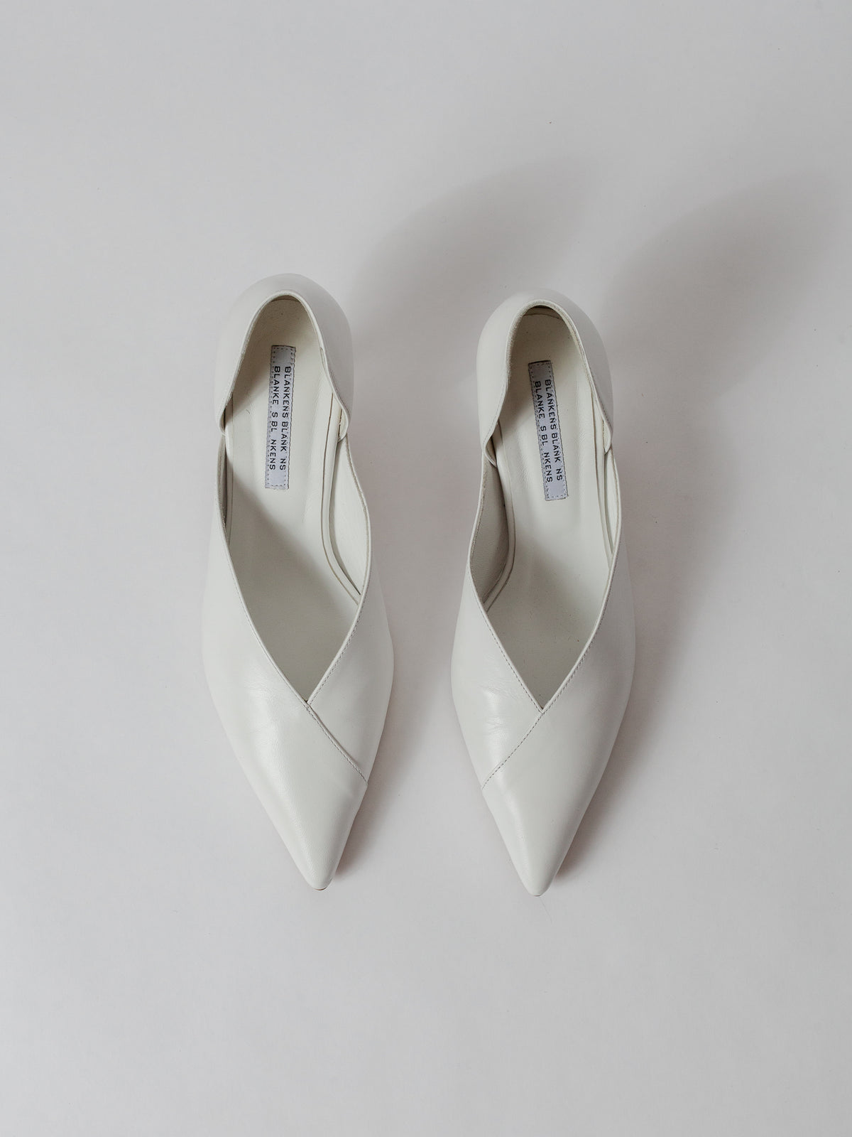 Blankens The Radford white Pair of white pointed-toe shoes on a light gray background