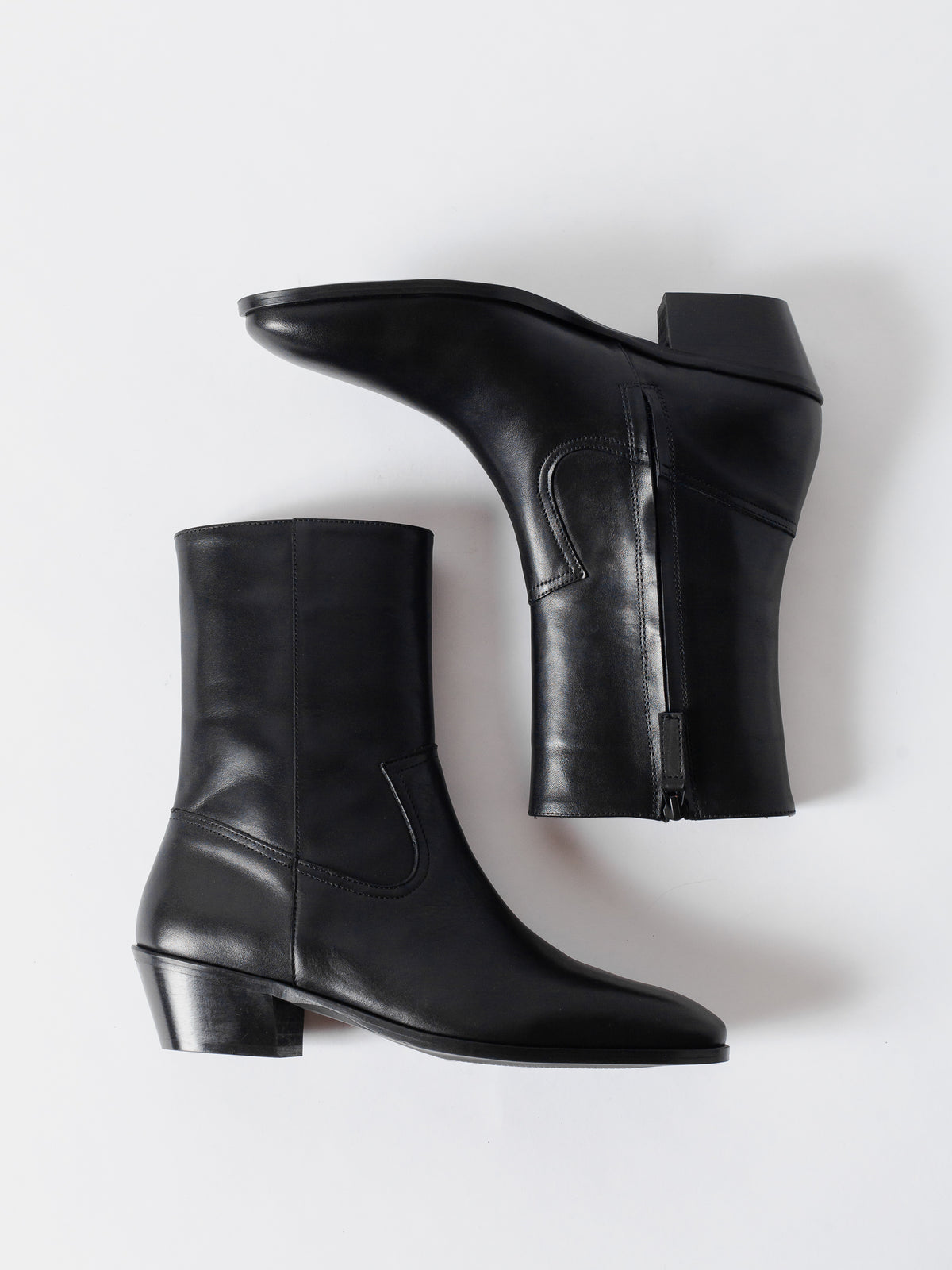 Pair of black leather ankle boots on a white background