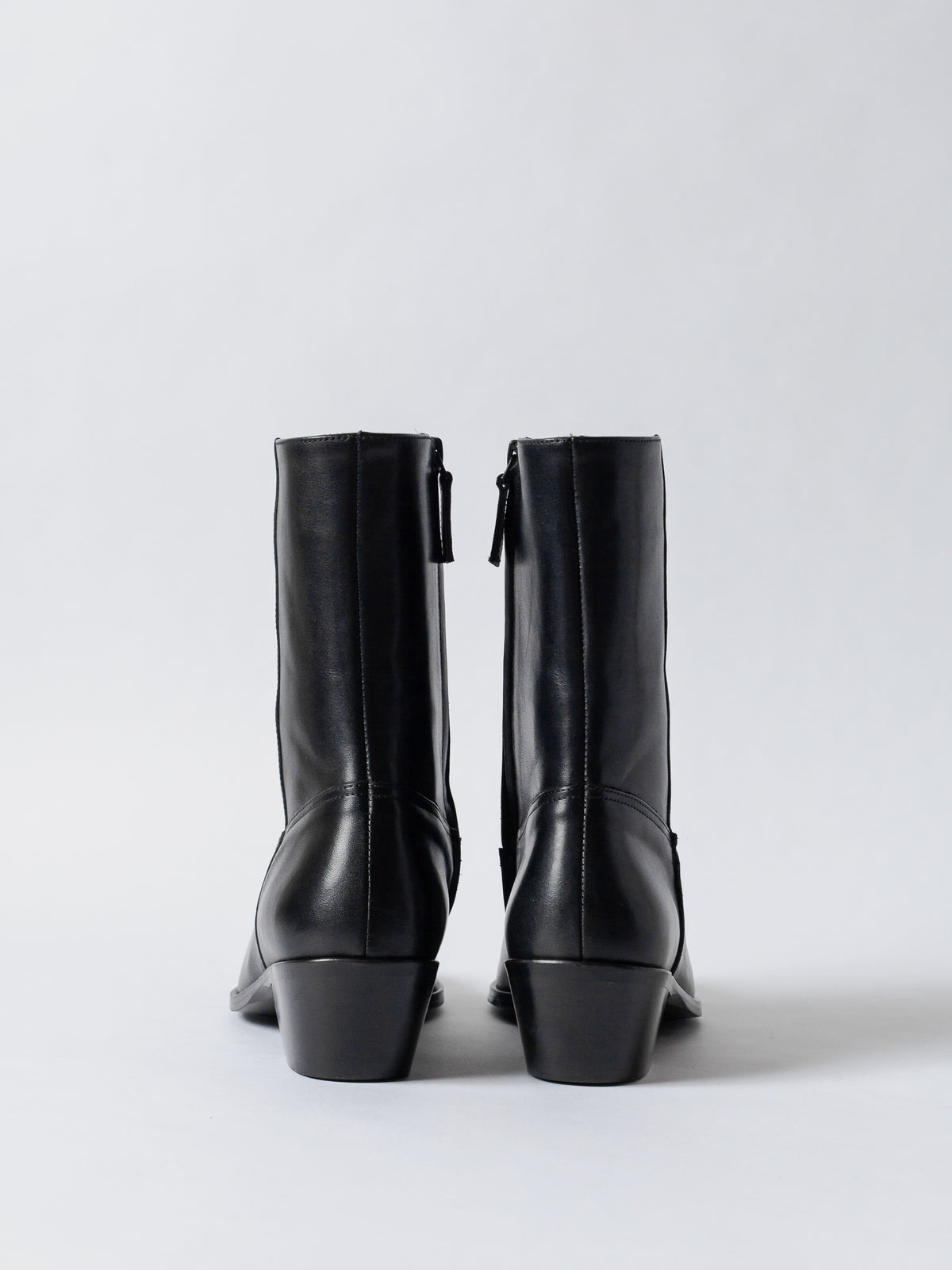 Pair of black leather boots on a white background