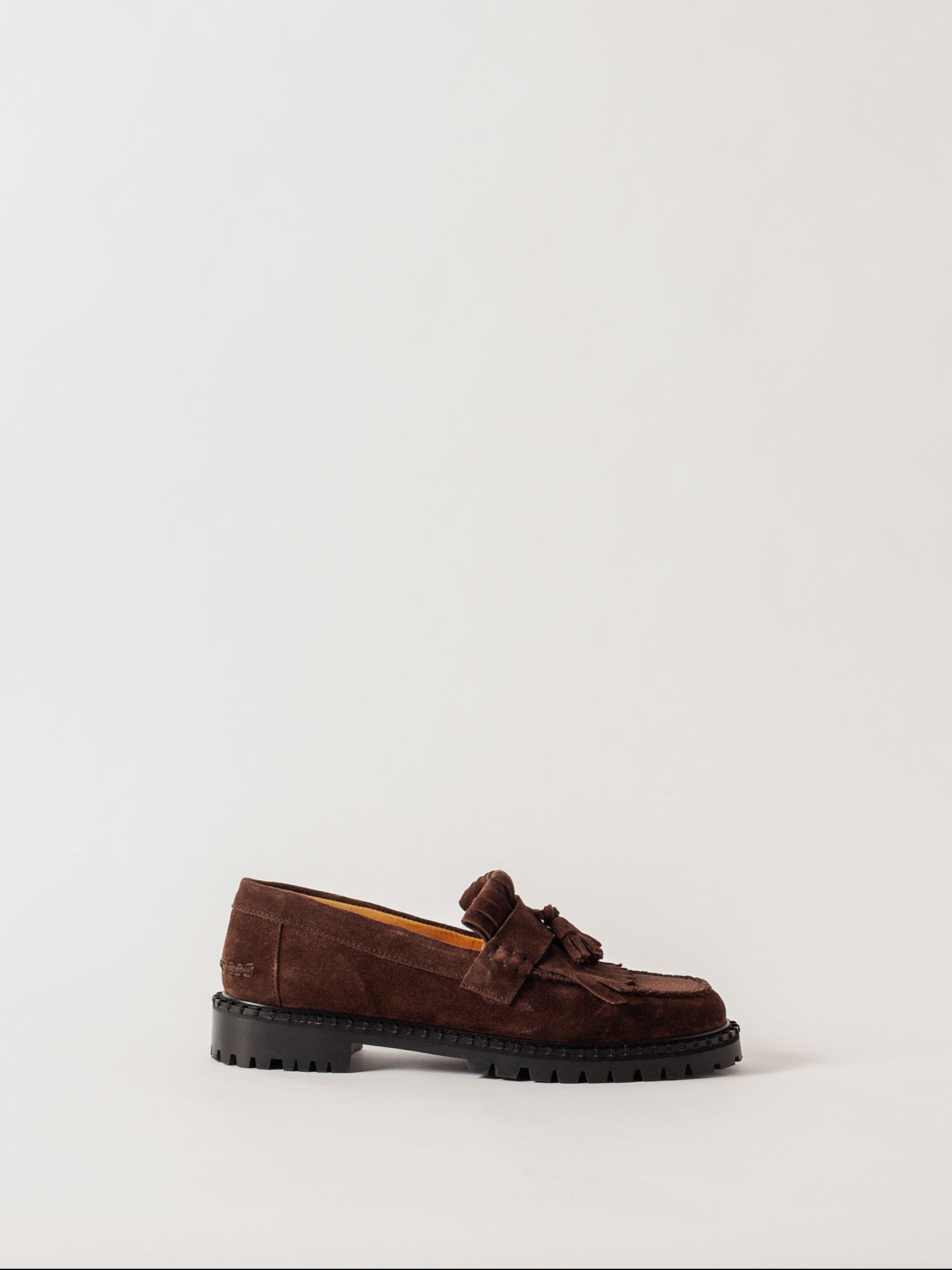 Brown loafers with a knot on a light gray background