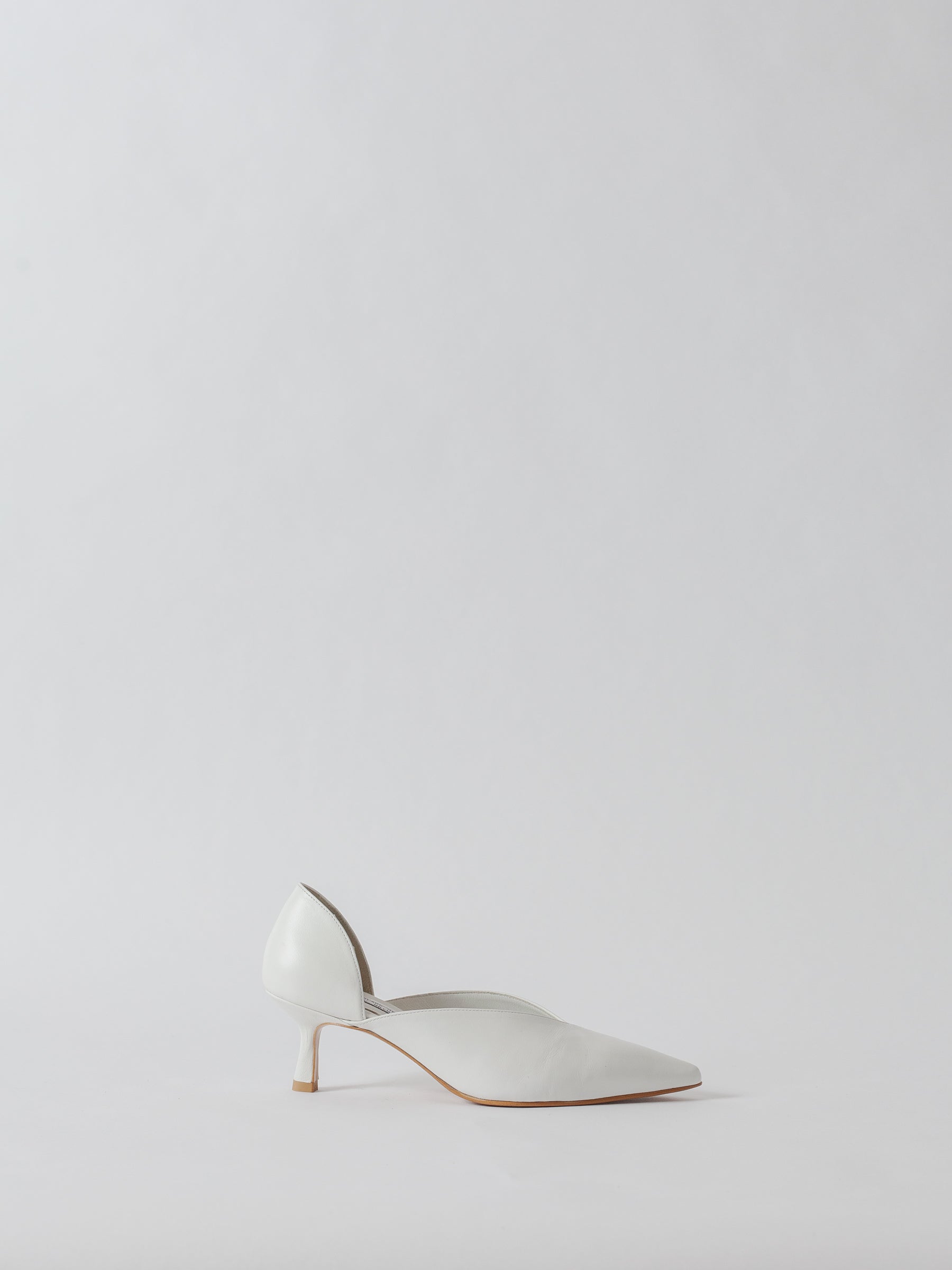 White high-heeled shoe on a light gray background