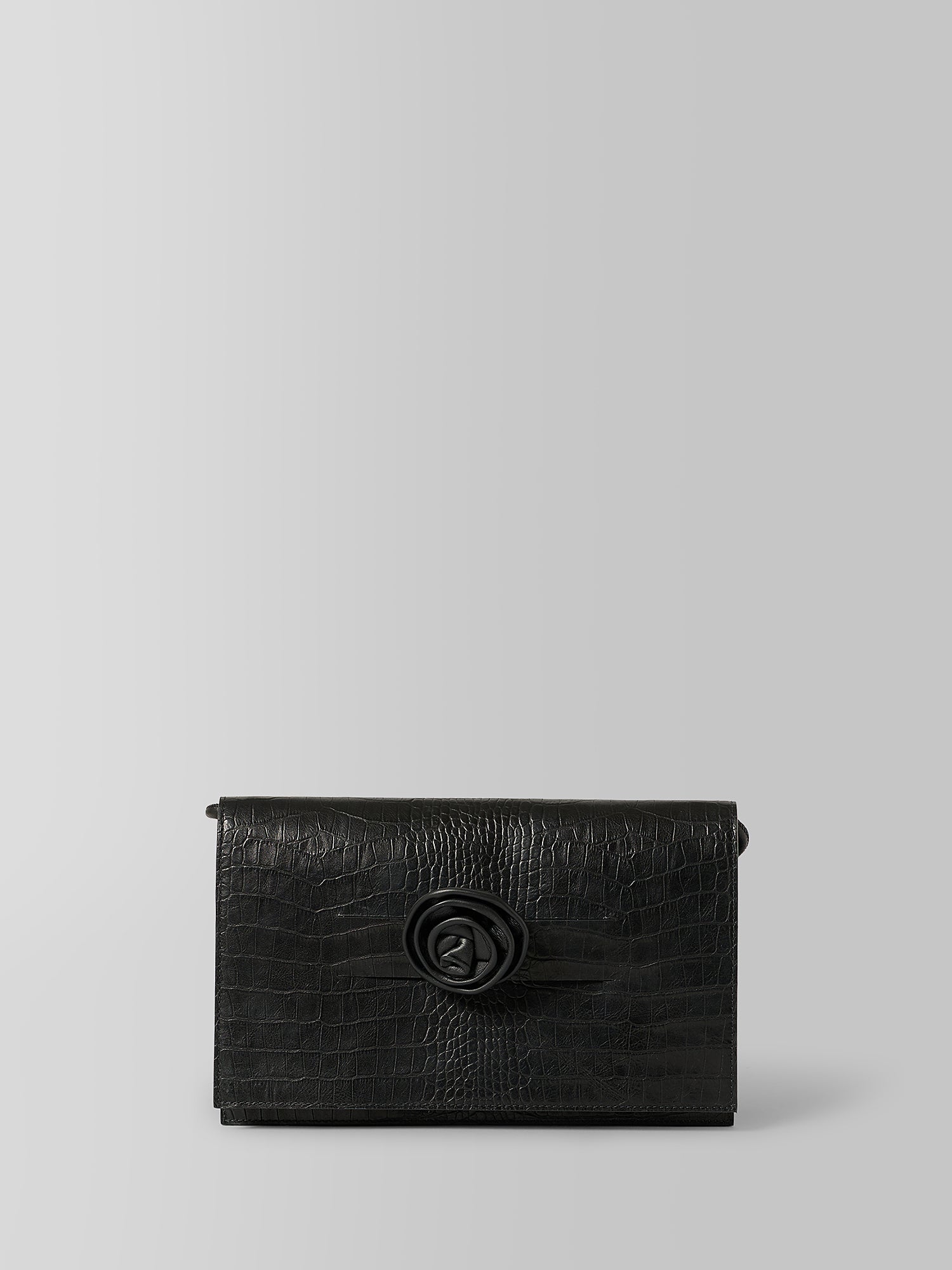 A black textured leather clutch bag with a crocodile pattern and a central 3D rose clasp, photographed against a neutral light gray background.