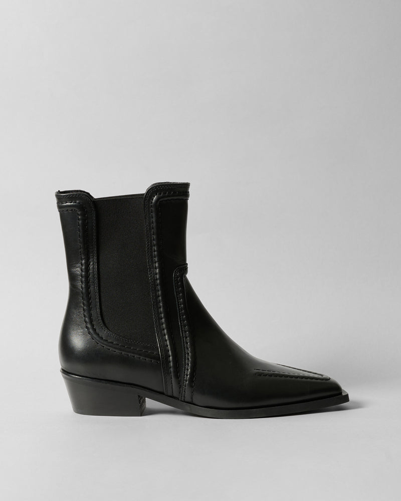 Black ankle boot on a light gray background