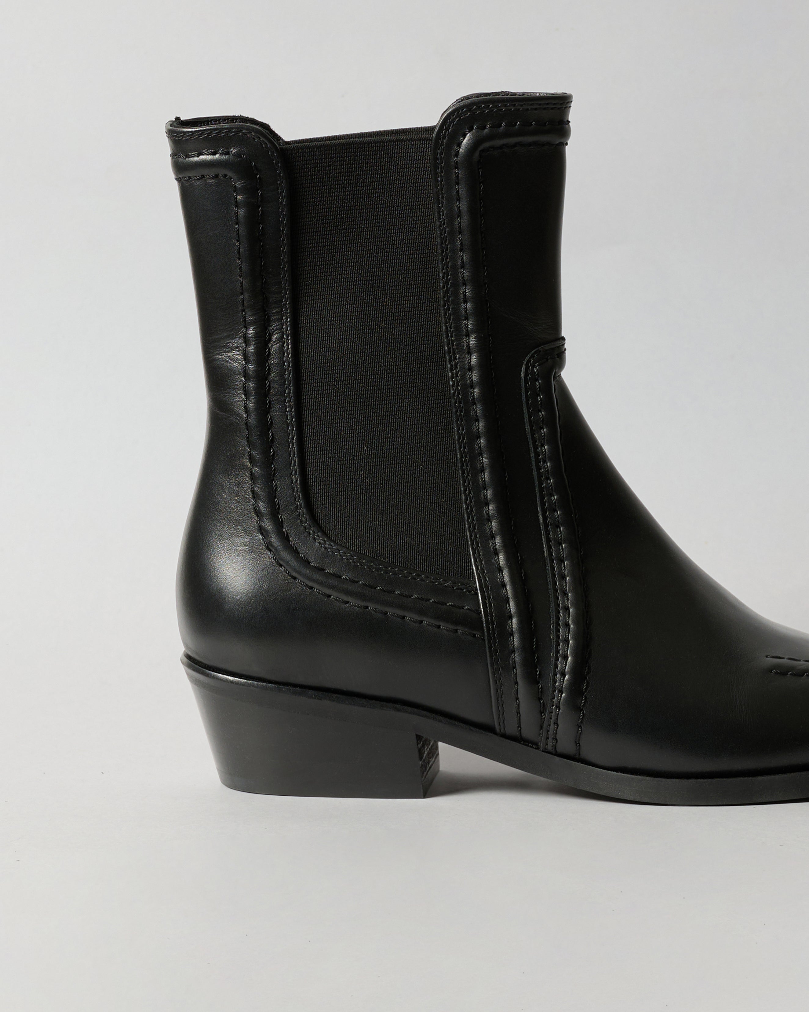 Black ankle boot on a light gray background