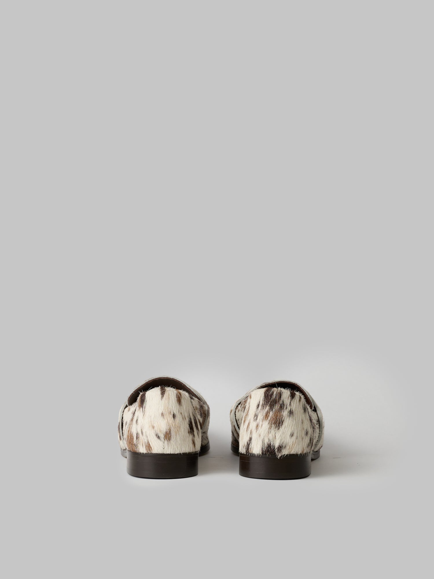 Pair of black and white patterned loafers on a light gray background