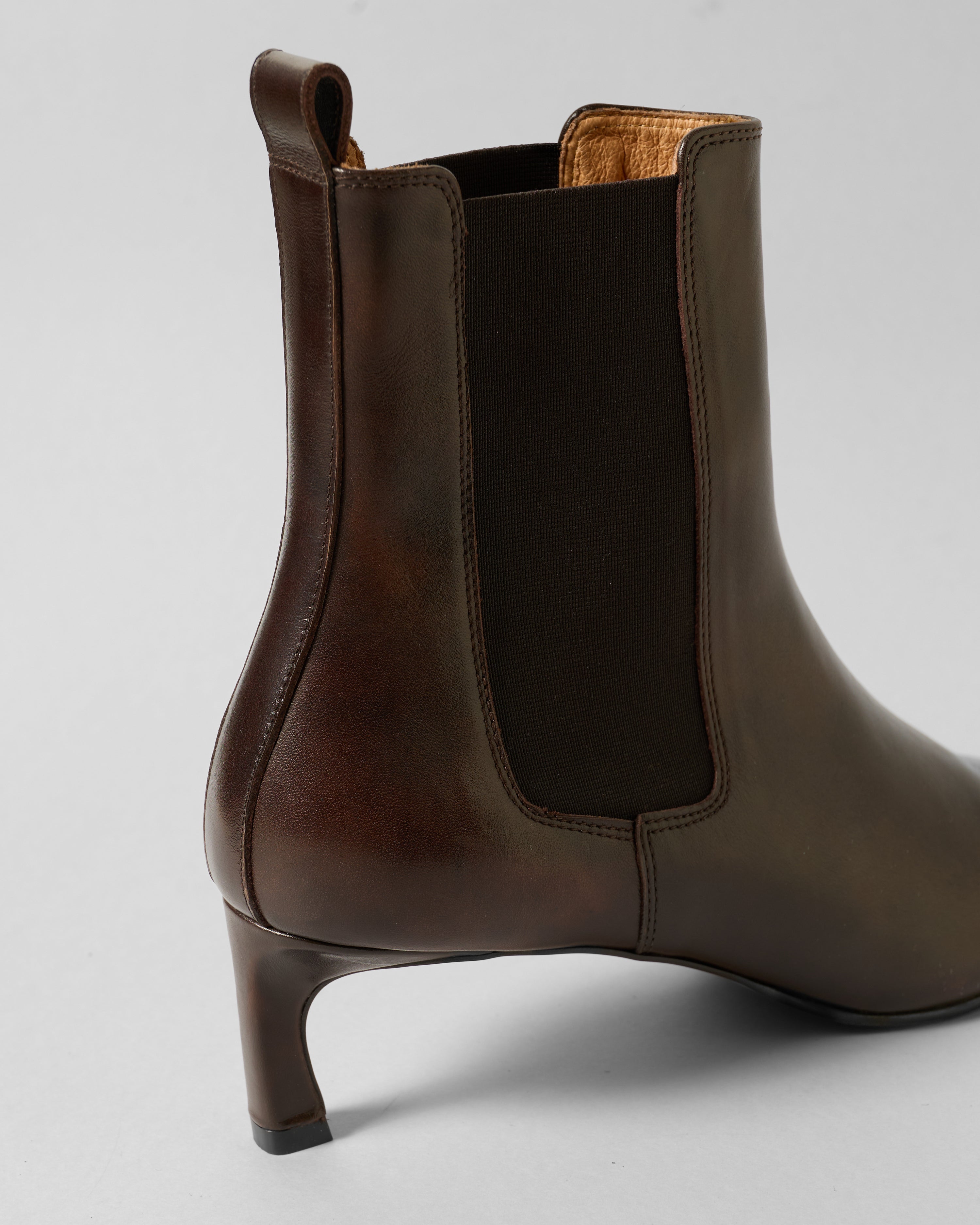Brown leather ankle boot on a light gray background