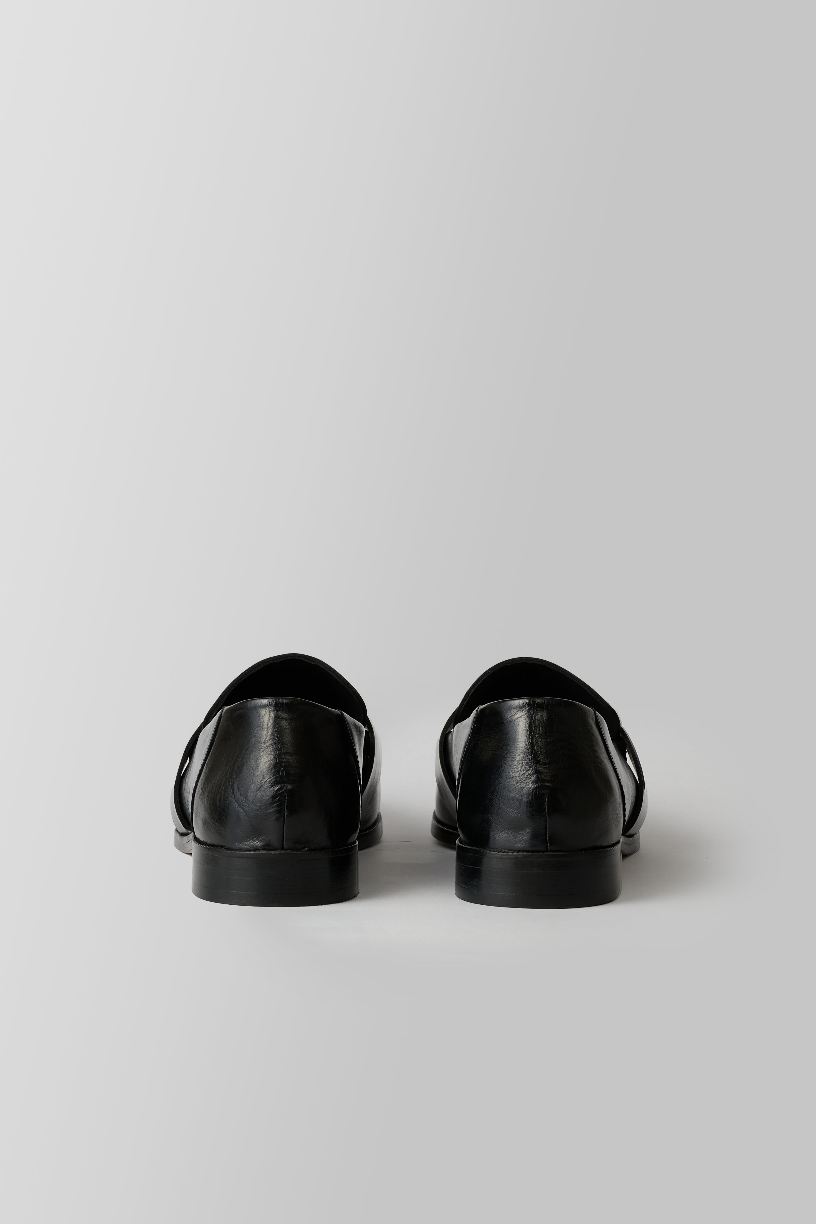 Black loafer with a strap on a white background